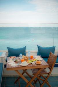 马赫迪耶Hôtel Al Jazira Mahdia的一张桌子,上面有食物,享有海景 更多30张照片