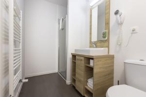 a bathroom with a sink and a mirror at Appart Hotel Odalys City Metz Manufacture in Metz +53 photos