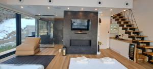 ein Wohnzimmer mit Kamin und Fernseher in der Unterkunft Valdora - Forest Oasis  + 22 Fotos