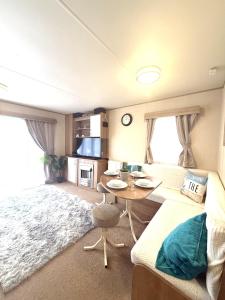 een woonkamer met een bank en een tafel bij Paddy's Place in Filey