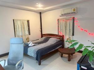 una piccola camera da letto con un letto e una sedia di Paradise waterfall house a Ko Phangan