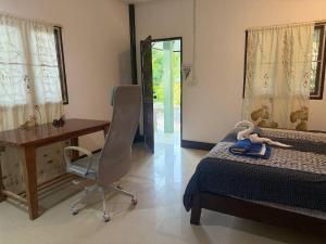 una camera da letto con un letto, una scrivania e una sedia di Paradise waterfall house a Ko Phangan
