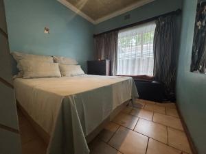 een slaapkamer met een groot bed en een raam bij Chic 3-bed home with comfort in Pretoria