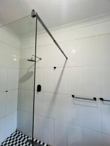 een douche met een glazen deur in een badkamer bij Chic 3-bed home with comfort in Pretoria