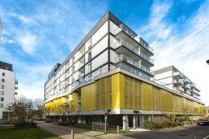 a yellow and white building on a city street at Appart Hotel Odalys City Metz Manufacture in Metz