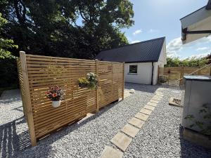 Una cerca con flores al lado de una casa en 1st Class Escape, en Kågeröd 3 fotos más