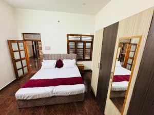 a bedroom with two beds and a mirror at Rooms in appartment by LUXE in Mysore