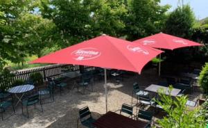 HeubachLandgasthof Rhönsicht的红色伞下的桌椅