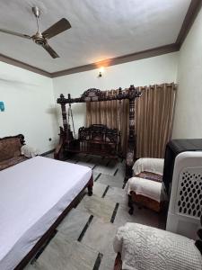 a bedroom with two beds and a ceiling fan at Rooms in appartment by LUXE in Mysore