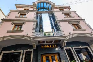 ein rosafarbenes Gebäude mit einem Londoner Schriftzug darauf in der Unterkunft Hotel BRILANT ANTIK City Center in Tirana