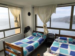 El Peñon Rodadero building - incredible view في Puerto de Gaira: غرفة نوم بسريرين وإطلالة على الماء +25 صورة