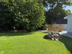 Un patio con un árbol y un montón de piedras en 1st Class Escape, en Kågeröd