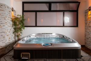 a jacuzzi tub in a room with a window at Hotel Bella Italia Piancavallo in Piancavallo +27 photos