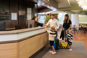 a family standing at a bar in a restaurant at Hotel Bella Italia Piancavallo in Piancavallo