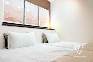 1 cama blanca con 2 almohadas en una habitación en WeeklyHouse Schildkrote, en Otsu