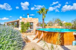 a pool in front of a house with a palm tree at Finca Can Puput Bó in Son Gual