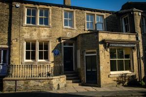 an old brick building with a door and stairs at The Brontë Birthplace in Thornton
