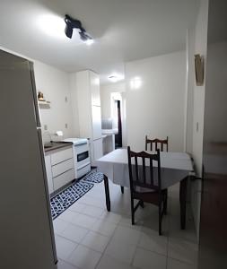 a kitchen and dining room with a table and a chair at Cobertura com 4 quartos e ar condicionado in Cabo Frio