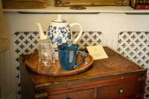 a table with a vase and cups on a wooden tray at The Brontë Birthplace in Thornton