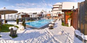a house with a swimming pool in the snow at Vakantiehotel Der Brabander in Winterberg