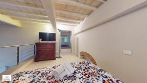 una camera da letto con un letto e una TV in una stanza di Loft Matteotti by Florence Sweet Homes a Scandicci