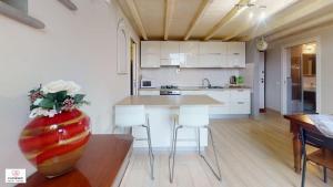 una cucina con tavolo, sedie e vaso fiorito di Loft Matteotti by Florence Sweet Homes a Scandicci