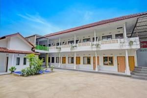 ein großes weißes Gebäude mit einem roten Dach in der Unterkunft Collection O Subang near Ciater Subang formerly Orchid Villa Ciater in Ciater