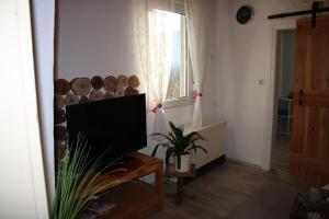ein Wohnzimmer mit einem TV und einem Fenster in der Unterkunft Haus Ewald in Enkirch