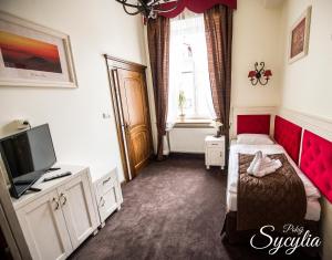 a bedroom with a red bed and a tv at Sempre B&B in Płock