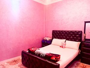 塔哈佐特Azazoul Apartment Taghazout的一间卧室，床上有红色枕头