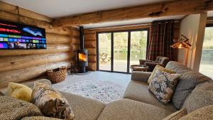 ein Wohnzimmer mit Sofa und Fernseher in der Unterkunft Kingfisher Cabin in Broughton in Furness