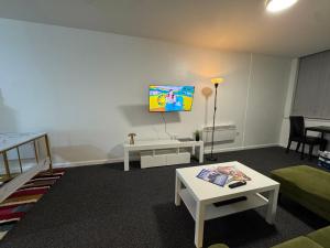 a living room with a couch and a tv on the wall at Cosy Studio Escape in Ilkeston with Netflix in Ilkeston
