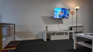 a living room with a tv hanging on the wall at Cosy Studio Escape in Ilkeston with Netflix in Ilkeston +9 photos