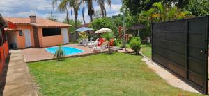 a backyard with a black fence and a swimming pool at Chácara do Juscelino in Monte Sião