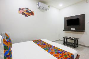 a hotel room with a bed with a colorful blanket at Hotel Brook View in Surat +42 photos