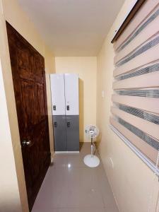 a bathroom with a toilet and a large door at JOs HOMEtel at Heritage City of the South Carcar in Guinauayan