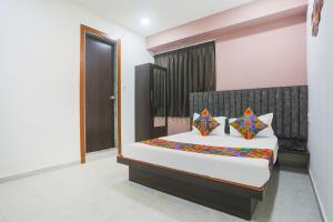a bedroom with a large bed with colorful pillows at Hotel Brook View in Surat