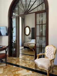 een woonkamer met een stoel en een spiegel bij Dimora Donna Elena in Napels