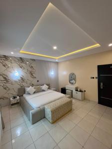 una camera da letto con un grande letto bianco e un divano di Sweet Home hotel a Lekki