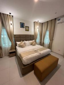 una camera da letto con un grande letto e un pouf di Sweet Home hotel a Lekki