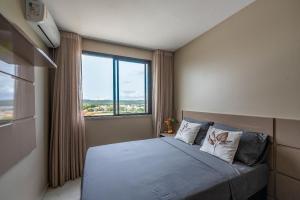 Un dormitorio con una cama con una ventana grande. en Vista Baía do Pontal • Piscina • Ao Lado Gbarbosa, en Pontal de São João da Barra 35 fotos más