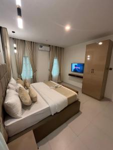 una grande camera da letto con un grande letto e una televisione di Sweet Home hotel a Lekki
