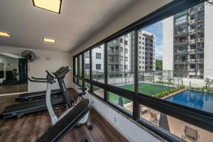 un gimnasio con cinta de correr y vistas a la piscina en Vista Baía do Pontal • Piscina • Ao Lado Gbarbosa, en Pontal de São João da Barra