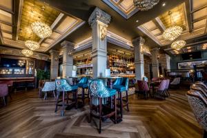 a bar with blue chairs and tables in a restaurant at Walled City Hotel in Derry Londonderry