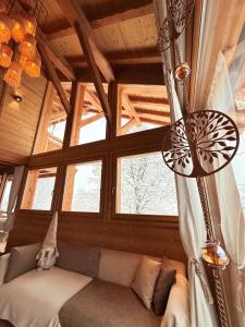 um quarto com um sofá em uma sala com janelas em Chalet Grand Area em Briançon