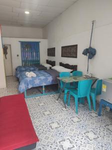 a bedroom with a bed and a table and chairs at BALLESTRINQUE - GETSEMANI- CARTAGENA DIVINa in Cartagena de Indias