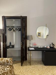 een kamer met een bureau, een spiegel en een bed bij Dimora Donna Elena in Napels