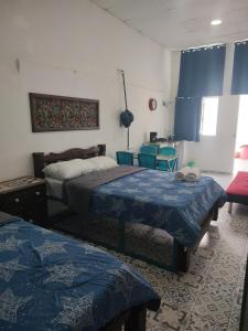 a bedroom with two beds and a table and chairs at BALLESTRINQUE - GETSEMANI- CARTAGENA DIVINa in Cartagena de Indias +2 photos