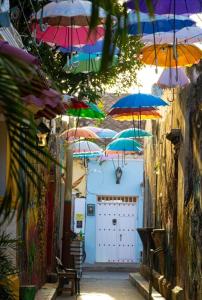 a bunch of umbrellas in an alley with a garage at BALLESTRINQUE - GETSEMANI- CARTAGENA DIVINa in Cartagena de Indias