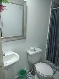 a bathroom with a toilet and a sink and a mirror at BALLESTRINQUE - GETSEMANI- CARTAGENA DIVINa in Cartagena de Indias